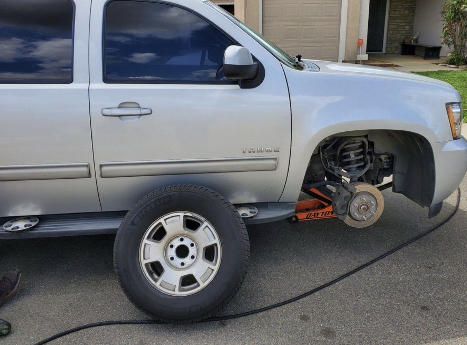 Wheel off and parts staged at a Lake Charles curbside brake job