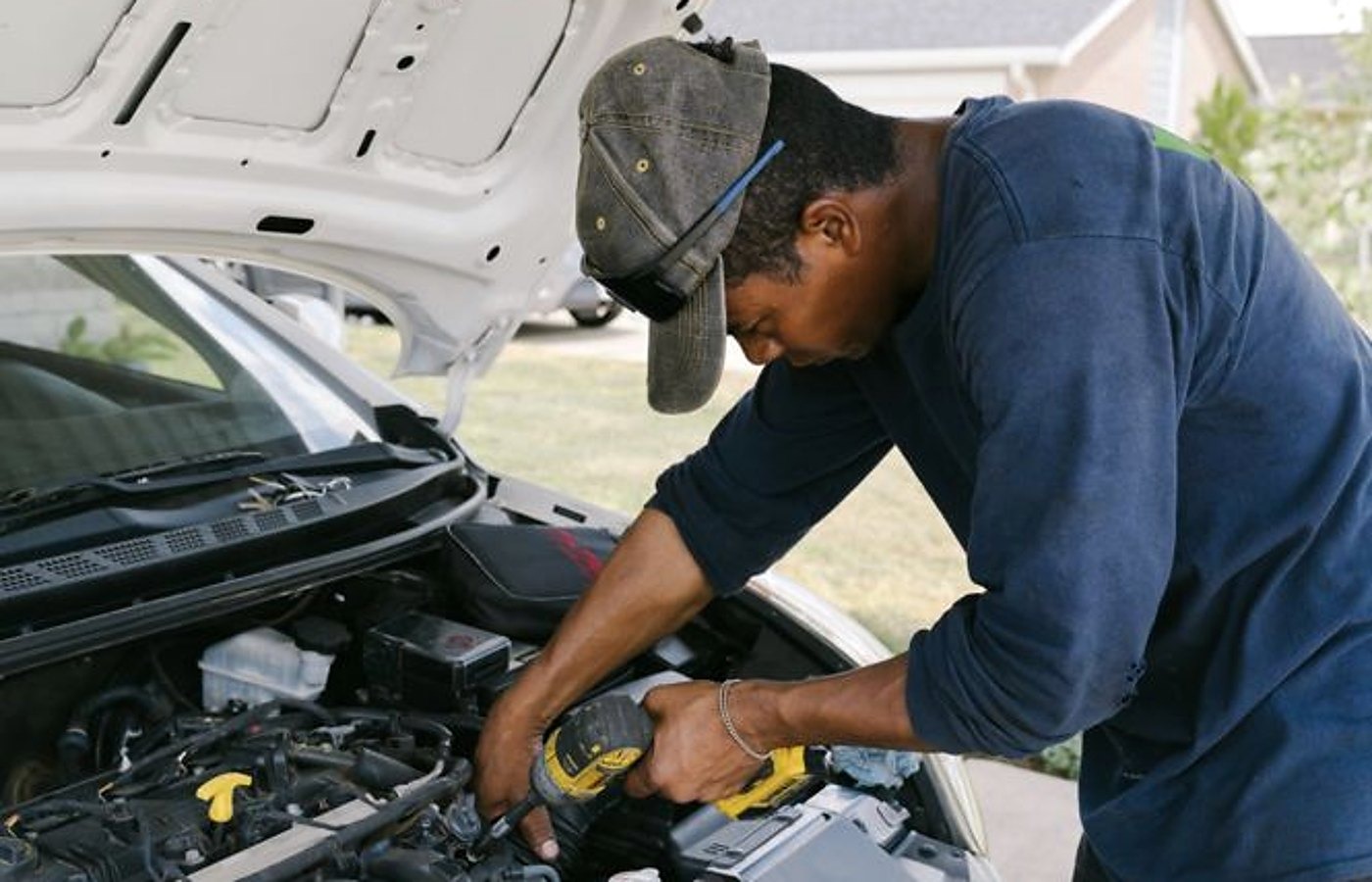 Lake Charles mobile mechanic at work under a customer hood